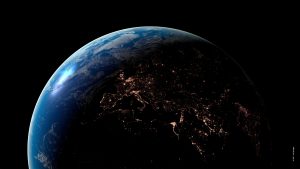 Die Erde vom Weltraum betrachtet, auf der Nachtseite sind im Schatten die Lichtermeere vieler Städte zu sehen
